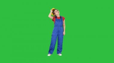 Chroma anahtar yeşil ekranda zor iş günü sonra inşaat giysili yorgun kadın.