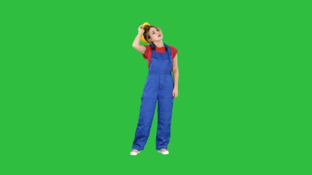 Trött kvinna i konstruktion kläder efter hård arbetsdag på en grön skärm, Chroma Key. — Stockvideo