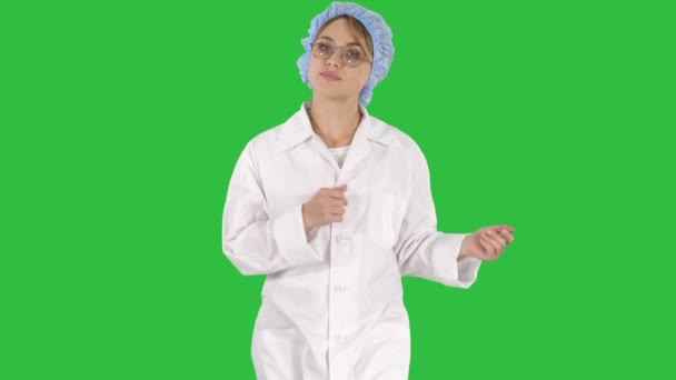 Vackra läkare pratar medan promenader på en grön skärm, Chroma Key. — Stockvideo