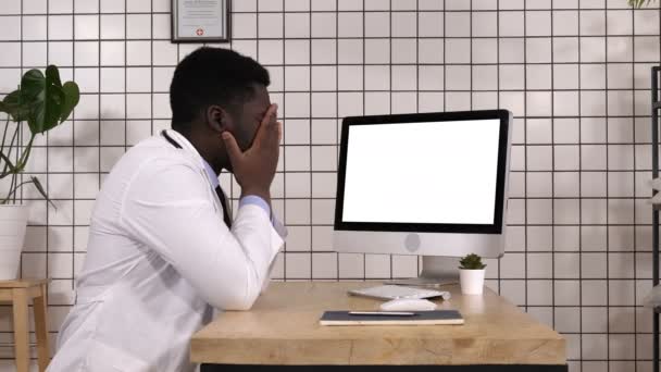Σοκαρισμένος ιατρική γιατρό που ψάχνετε στην οθόνη του υπολογιστή. Λευκή οθόνη. — Αρχείο Βίντεο