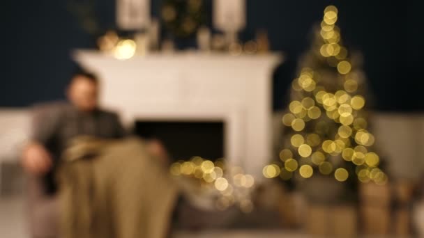 Mladý muž spí v křesle na Štědrý večer. Nudný vánoční koncept. — Stock video
