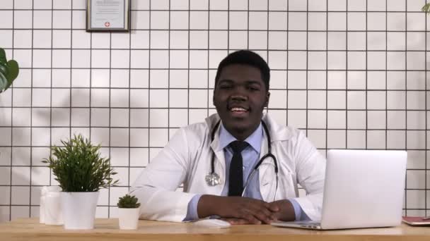 Tengo buenas noticias para ti. Alegre joven médico africano diciendo buenas noticias a la cámara . — Vídeos de Stock