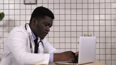 Resepsiyon ile dizüstü bilgisayar üzerinde çalışan doktor.