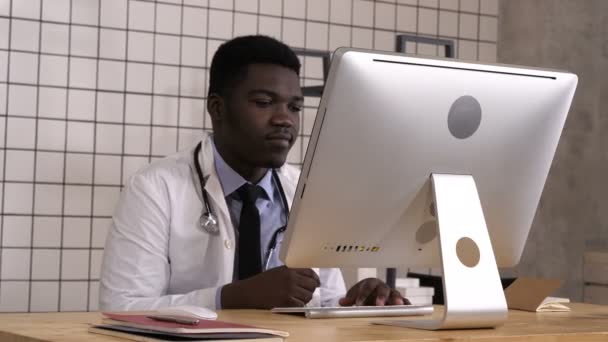 African American läkare på jobbet som tittar på skärmen på hans dator. — Stockvideo