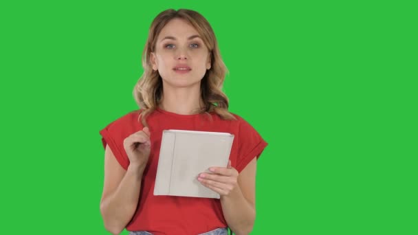 クロマキー グリーン画面でめくっているページを提示タブレット コンピューターと笑顔の女性. — ストック動画