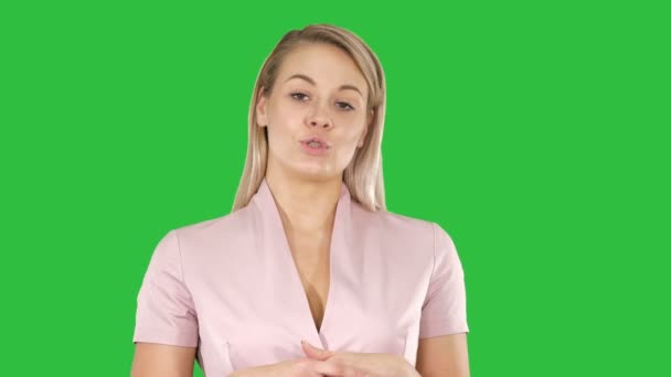 Junge Frau im Gespräch mit der Kamera auf einem grünen Bildschirm, Chroma-Taste. — Stockvideo