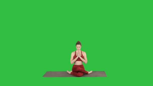Молодая привлекательная женщина практикующая йогу, сидящая в упражнении Гомукасана, поза "Лицо коровы" на зеленом экране, ключ хромы . — стоковое видео