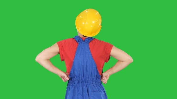 Ouvrière de la construction avec les mains sur les hanches regardant quelque chose sur un écran vert, Chroma Key . — Video