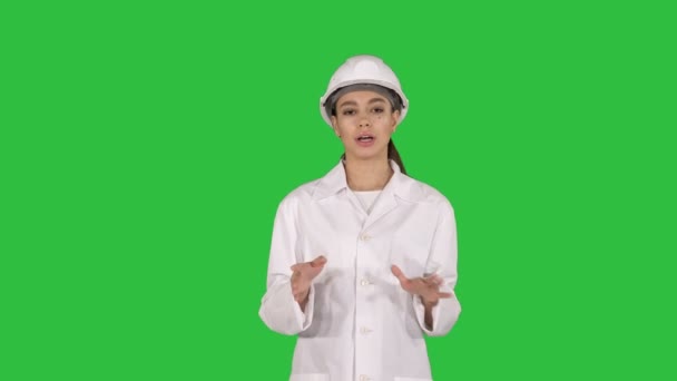 Femme ingénieur marche et parle à la caméra présentant quelque chose sur un écran vert, Chroma Key . — Video