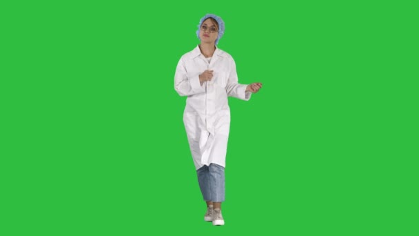 Amigable médico femenino caminando y hablando con la cámara en una pantalla verde, Chroma Key . — Vídeo de stock
