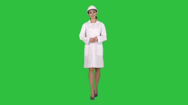 Mujer ingeniera madura en sombrero duro que indica al producto o texto con las manos mientras camina sobre una pantalla verde, Chroma Key . — Vídeo de stock