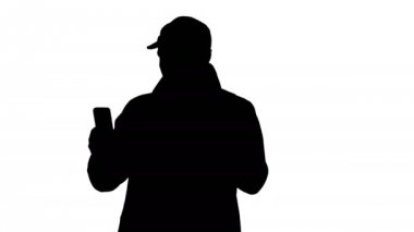 Siluet Genç adam yürürken cep telefonundan bir video görüşmesi yapıyor..