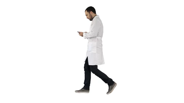 Férfi orvos, gyaloglás és a mobiltelefon használata a fehér háttér. — Stock Fotó