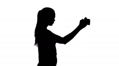 Siluet çekici, uzun, kumral saçlı, elinde farklı boş çantalar olan genç bir kadın..