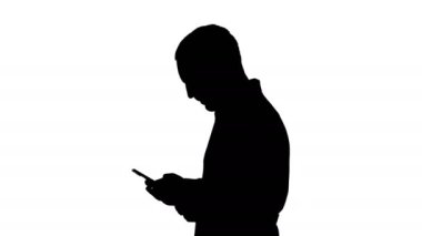 Siluet yürüyen doktor ya da hemşire cep telefonundan mesaj atıyor..