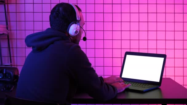 专业游戏玩家在他的笔记本电脑上玩电子游戏。白色展示. — 图库视频影像