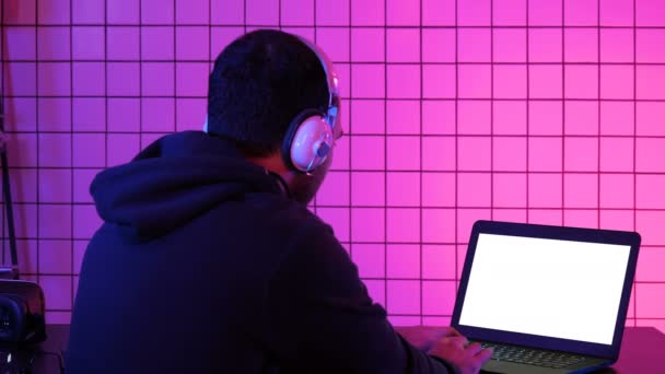 Man in headphone playing video game at home. White Display. — Stock Video