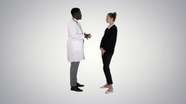 Erkek Afrikalı doktor Bayan hasta için degrade arka plan üzerinde konuşuyor.