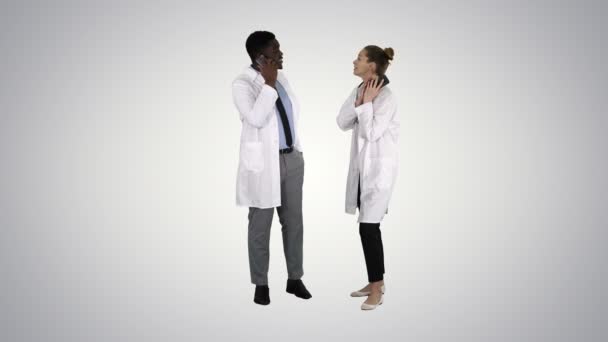 Ärztin und Arzt mit Mobiltelefonen, die auf dem Hintergrund des Gefälles freudige Nachrichten verkünden. — Stockvideo