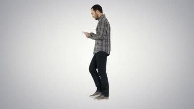 Yürüyüş ve tablet degrade arka plan üzerinde çalışan emin ciddi adam.