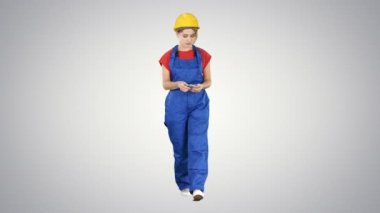 Degrade arka plan üzerinde yürürken para sayma kadın inşaat işçisi.