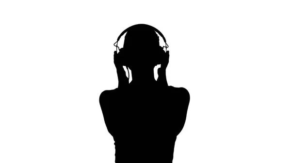 Γυναίκα σιλουέτα με ακουστικά, ακούγοντας μουσική και κάνοντας αστεία γκριμάτσα. — Φωτογραφία Αρχείου