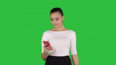 Mutlu genç kadın ile smartphone alışveriş çantalarını resmini Chroma anahtar yeşil ekran yapmak.