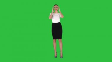 Kötülük ve Chroma Key bir yeşil ekranda aynaya bakıyor gibi onun görünümünü kontrol etek kız.