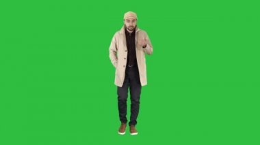 Trençkot güvenle kamera sadece konuşan genç adam konuşmaya taşımak ileri Chroma anahtar yeşil ekran.