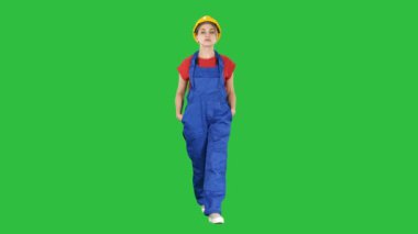 Chroma anahtar yeşil ekran yürüyüş Sarı kask ile genç kadın mühendis.