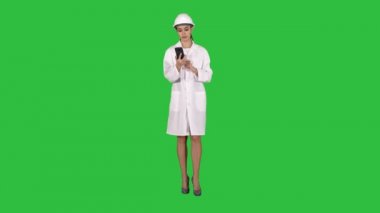 Chroma anahtar yeşil ekran yürürken telefonda konuşurken kadın mühendis.
