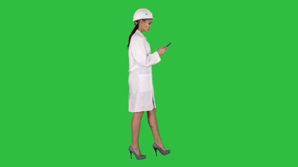 Ingeniero que usa mensajes de texto de teléfonos móviles mientras camina en una pantalla verde, Chroma Key . — Vídeos de Stock