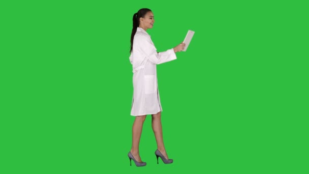 Jeune femme médecin tenant la tablette dans ses mains et faire un appel vidéo sur un écran vert, Chroma Key . — Video