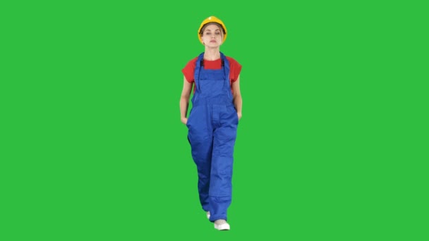 La jeune femme ingénieur avec casque de sécurité jaune marche sur un écran vert, Chroma Key . — Video