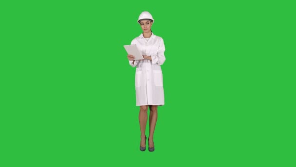 Ingeniera mujer revisando información y objetos en su tableta en una pantalla verde, Chroma Key . — Vídeo de stock