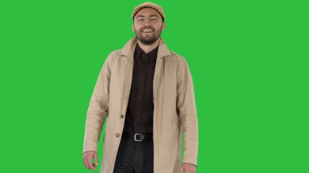 El hombre sonriente con abrigo está mirando a la cámara y caminando en una pantalla verde, Chroma Key . — Vídeo de stock