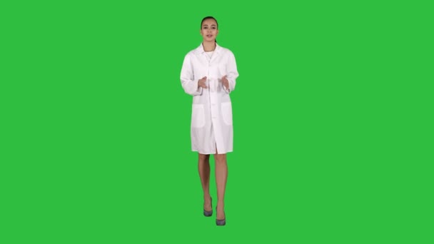 Γυναίκα γιατρός εξηγεί και μιλάει στην κάμερα ενώ το περπάτημα σε μια πράσινη οθόνη, Chroma Key. — Αρχείο Βίντεο