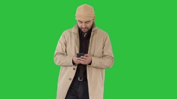 Jonge knappe man in berichten met de telefoon op een groen scherm, Chromakey mantel. — Stockvideo
