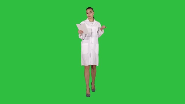 Geneeskunde, farmacie, mensen, gezondheidszorg en farmacologie concept - glimlachend vrouwelijke arts met tablet pc wandelen en lezen om de camera op een groen scherm, Chromakey. — Stockvideo