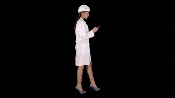 Инженер с помощью мобильного телефона SMS во время ходьбы, Альфа-канал — стоковое видео