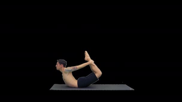 Esportivo muscular jovem yogi homem fazendo exercício backbend, dhanurasana, Bow Posture, Alpha Channel — Vídeo de Stock