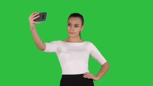 Lächelnde attraktive Frau, die ein Selfie macht, während sie auf einem grünen Bildschirm läuft, Chroma-Schlüssel. — Stockvideo