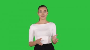 Yürüyüş ve açıklayan veya Chroma anahtar yeşil ekran sunan kameraya konuşurken işkadını.