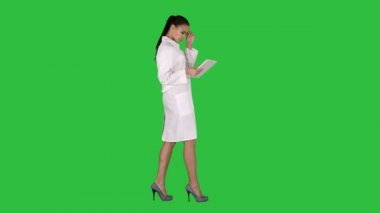 Kadın doktor tablet PC'yi kullanma ve yeşil ekranda Chroma Key yürüme.