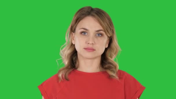 Jonge vrouw loopt rood t-shirt, camera kijken op een groen scherm, Chromakey. — Stockvideo