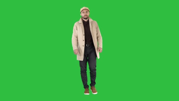 Man med mörka skägg i ljus trenchcoat promenader på en grön skärm, Chroma Key. — Stockvideo