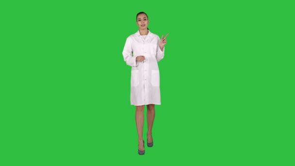 Ελκυστική γιατρός δείχνει προς την πλευρά που παρουσιάζει το προϊόν σε μια πράσινη οθόνη, Chroma Key. — Αρχείο Βίντεο