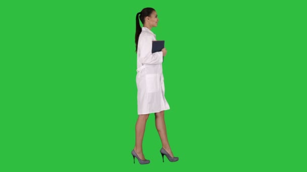 Feliz sonriente doctora caminando sosteniendo cuadernos o documentos en una pantalla verde, Chroma Key . — Vídeo de stock