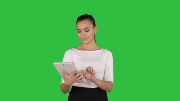 Sérieux attrayant jeune femme ou étudiant lisant des informations sur une tablette sur un écran vert, Chroma Key . — Video