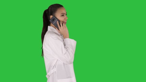 Perempuan Dr tersenyum sambil berbicara di telepon, berjalan di Layar Hijau, Chroma Key . — Stok Video